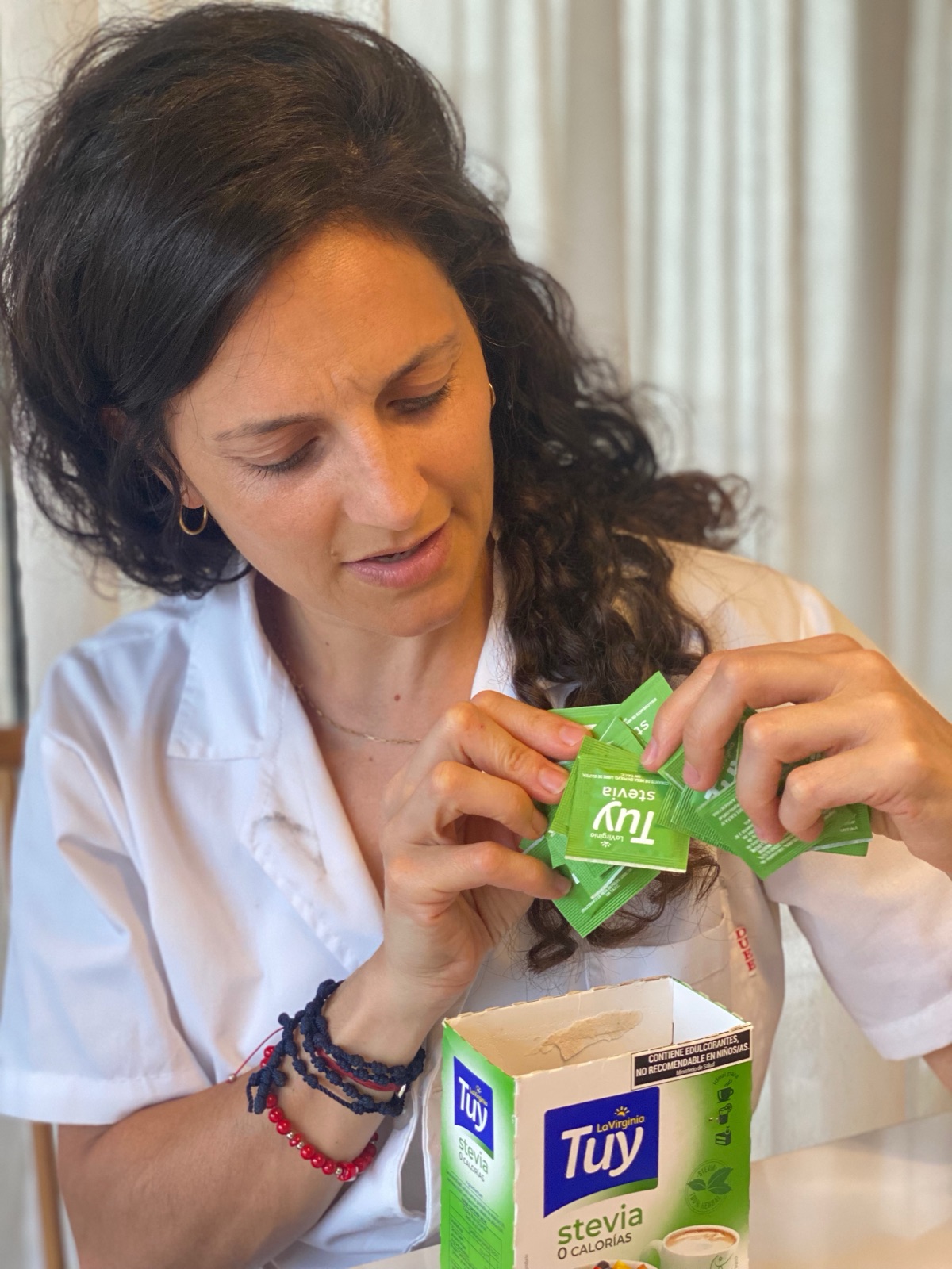 Juli con guardapolvo profesional analizando el etiquetado de un producto alimenticio